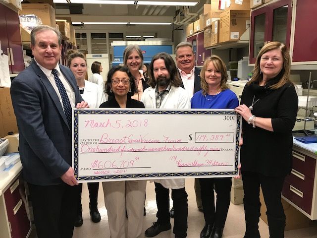 Dr. Tuohy and his research team with large check in 2018 for Breast Cancer Vaccine Fund | Brakes For Breasts