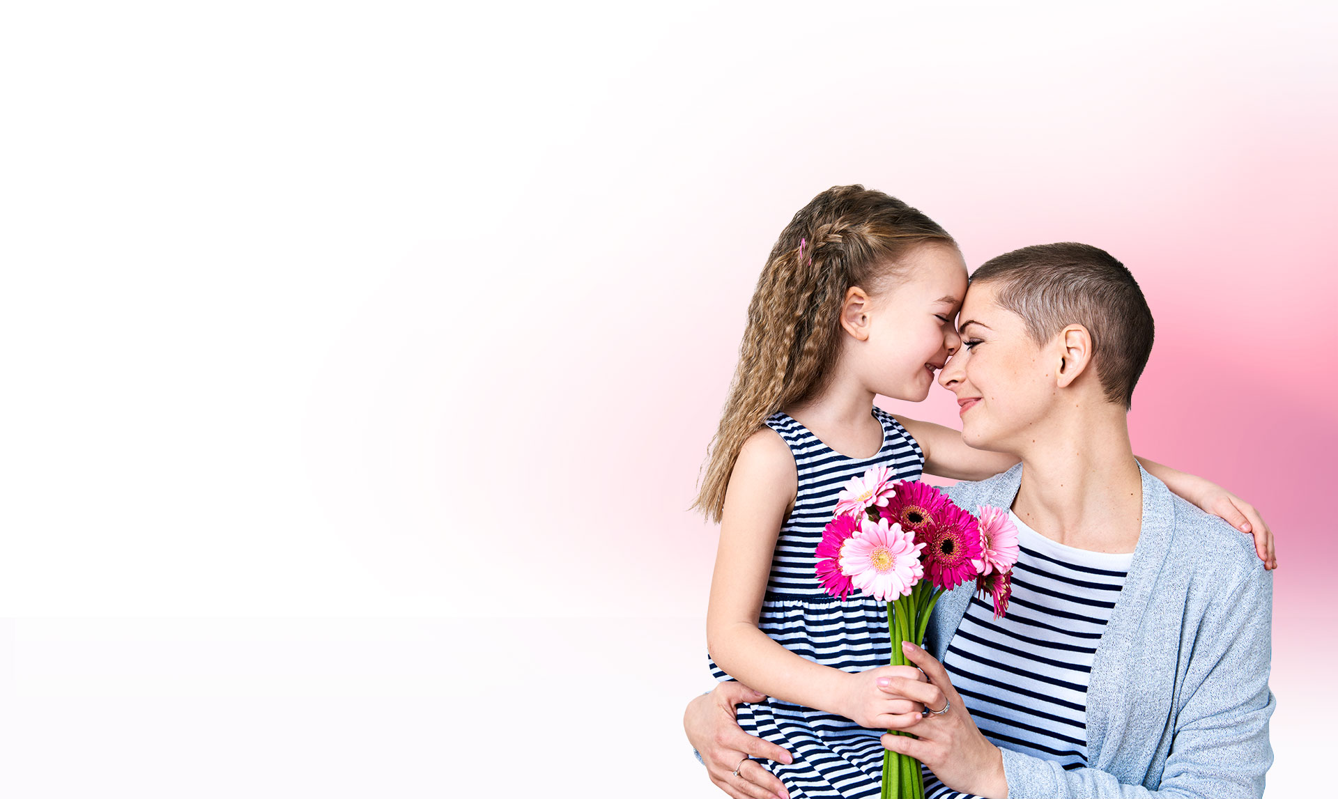 Woman posed with her daughter holding pink flowers, smiling | Brakes For Breasts