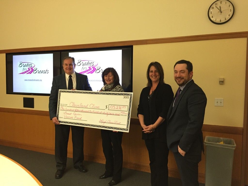Dr. Tuohy and group holding large check for Cleveland Clinic | Brakes For Breasts