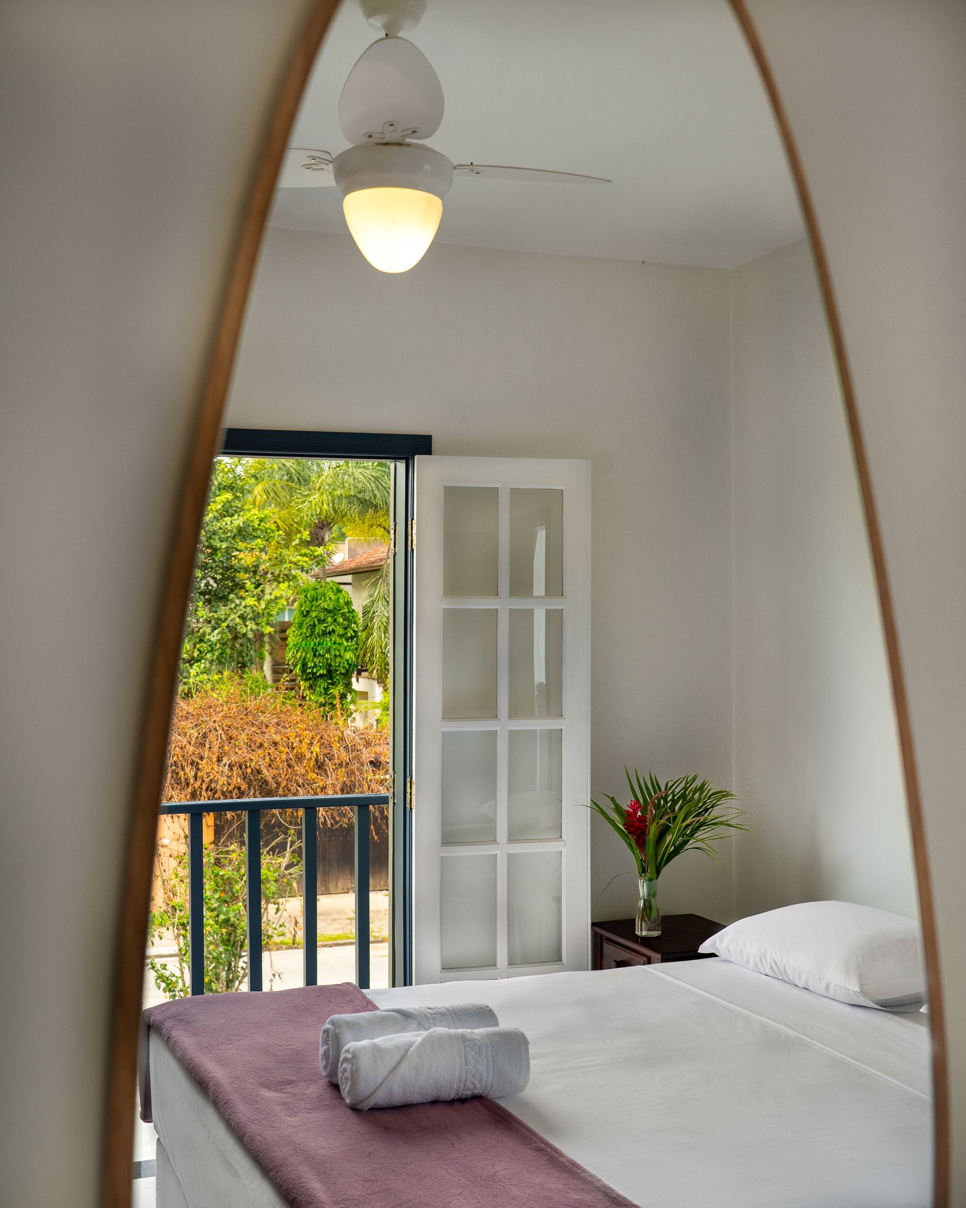 Um quarto com um espelho grande e um ventilador de teto