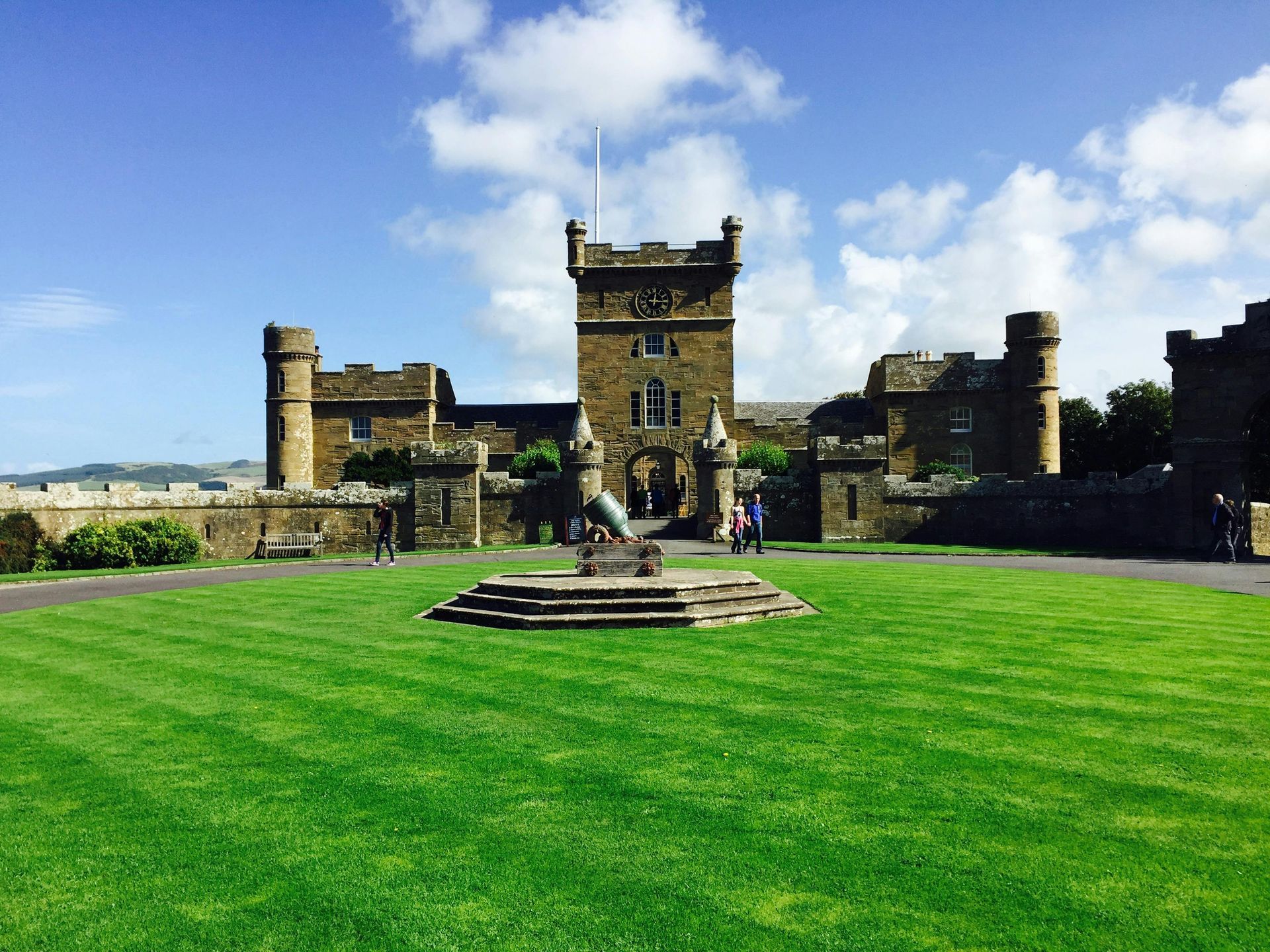 A large castle with a lush green lawn in front of it.