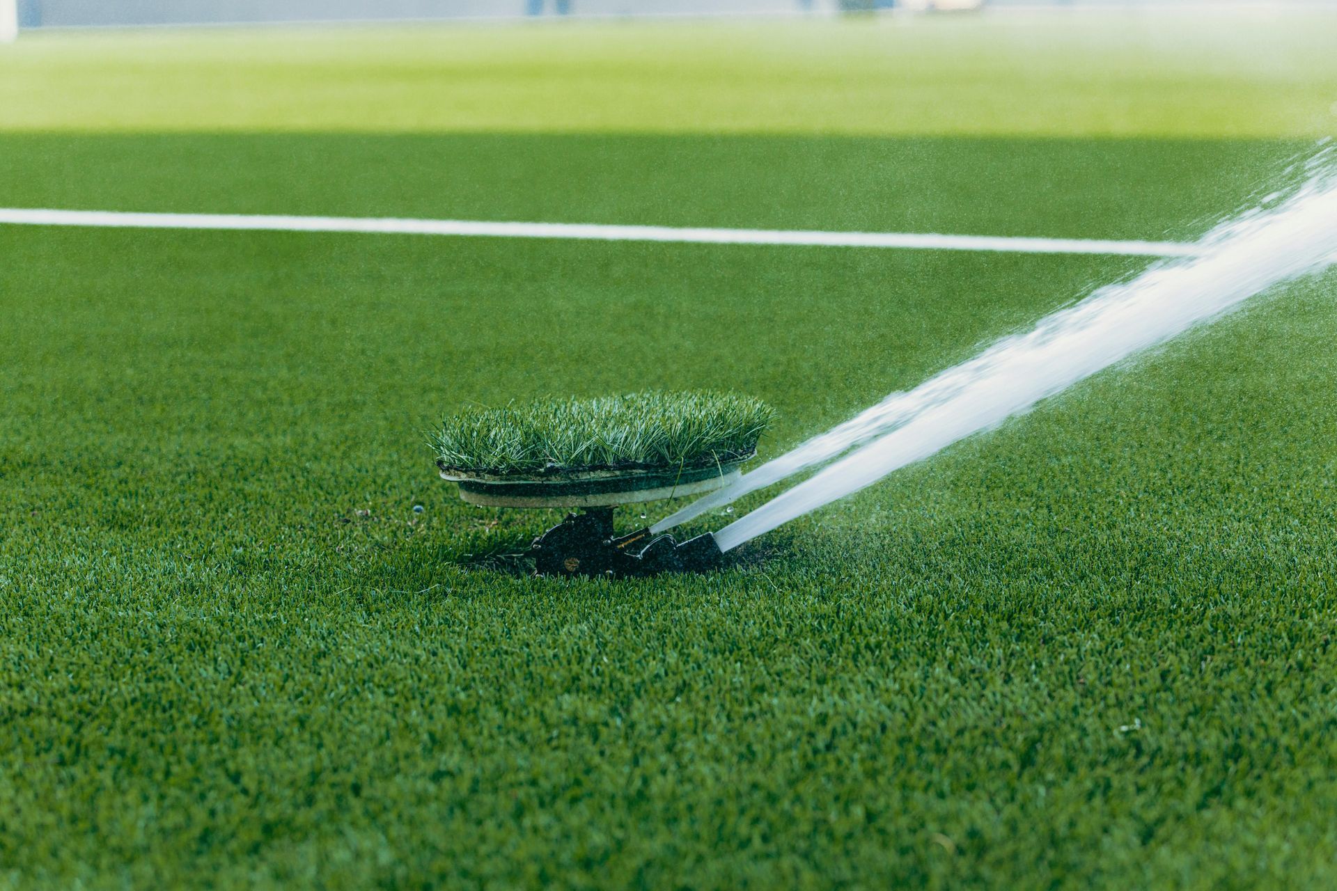 A sprinkler is spraying water on a soccer field.