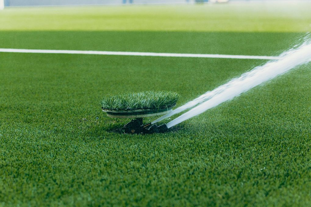 A sprinkler is spraying water on a soccer field.