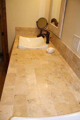 A bathroom counter with a sink , mirror and soap dish.