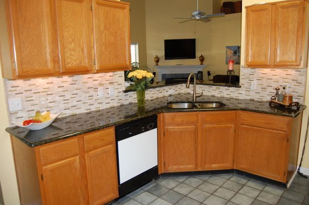 A kitchen with wooden cabinets and granite counter tops
