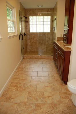 A bathroom with a walk in shower , sink , and toilet.
