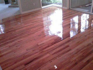 A living room with a wooden floor and a sliding glass door.