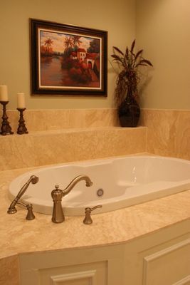 A bathtub in a bathroom with a picture on the wall above it.