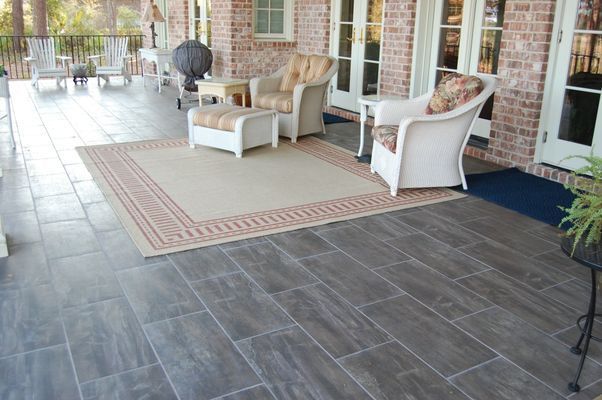 A patio with chairs and a rug on it