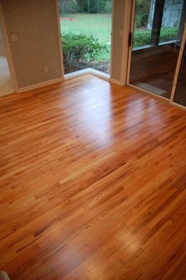 A living room with hardwood floors and a sliding glass door.