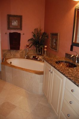 A bathroom with a tub , sink and mirror