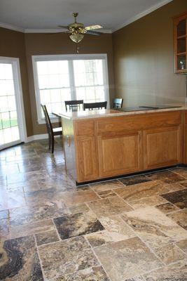 A kitchen with a large island and a ceiling fan.