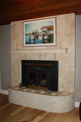 A fireplace with a picture on the wall above it