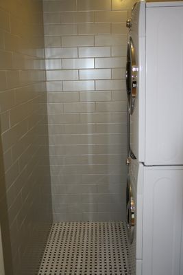 A washer and dryer are stacked on top of each other in a laundry room.