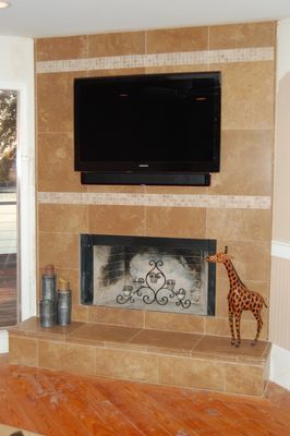A living room with a fireplace and a flat screen tv.