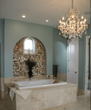 A bathroom with a tub and a chandelier hanging from the ceiling
