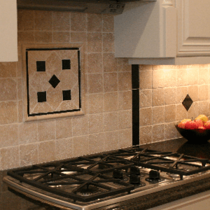 A stove top with a bowl of apples on it