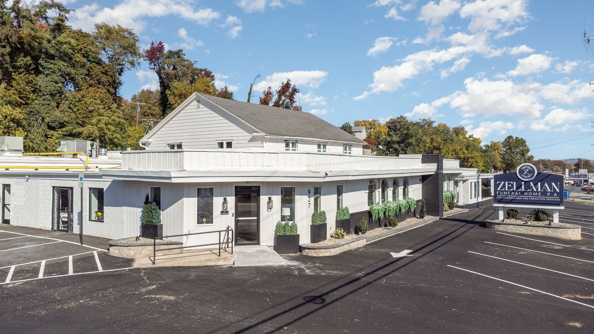 Exterior view of a white, single-story building; the sign reads 