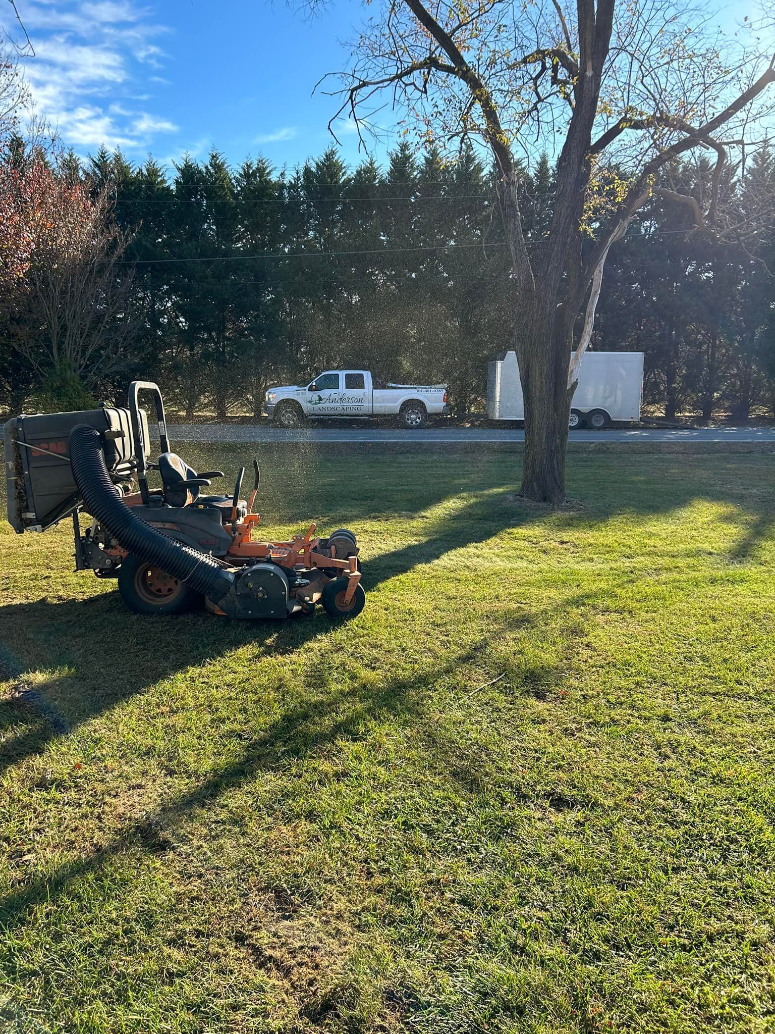 A lawn mower is parked in the middle of a lush green field.