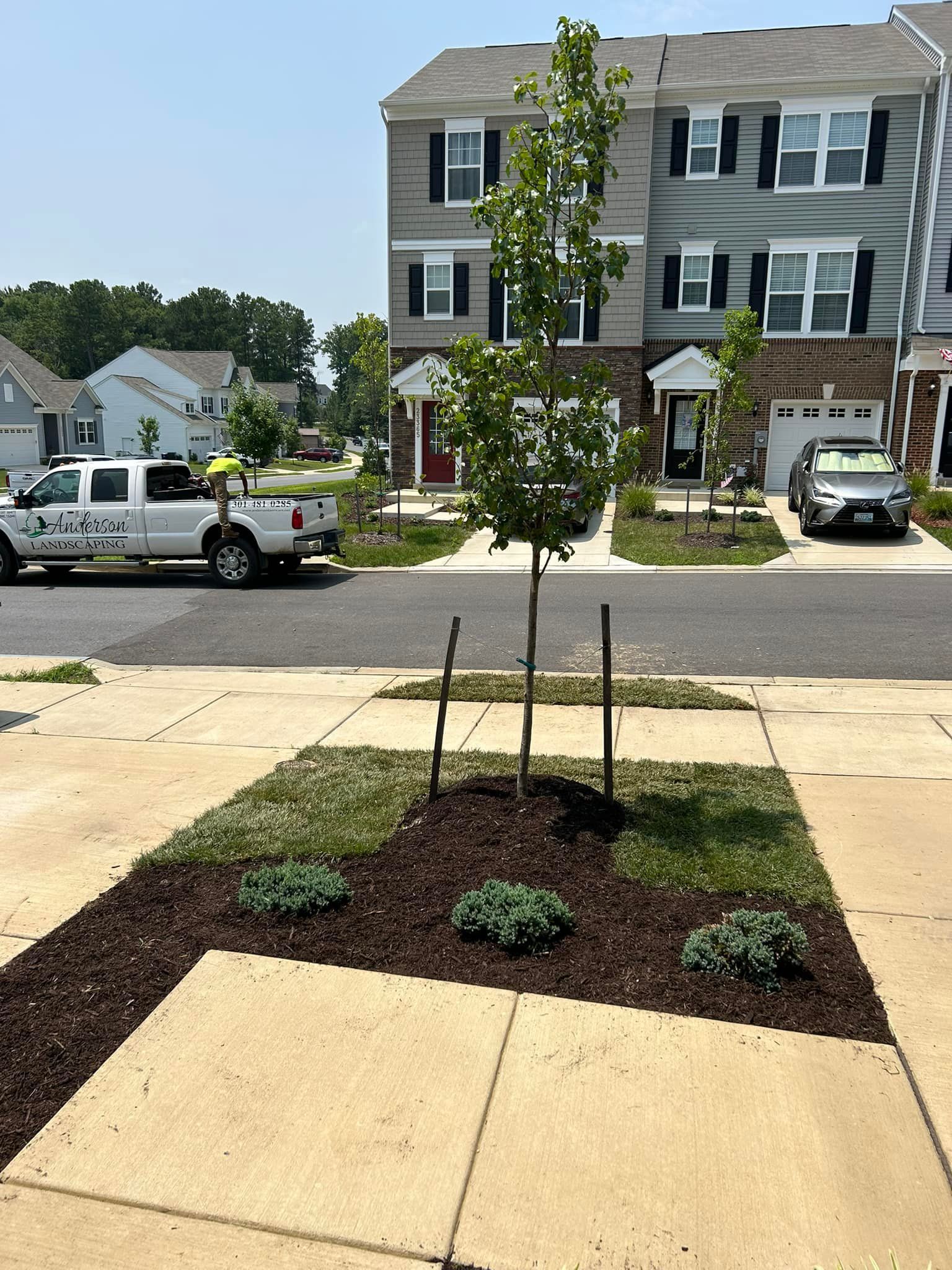 A white truck is parked in front of a house in a residential neighborhood.