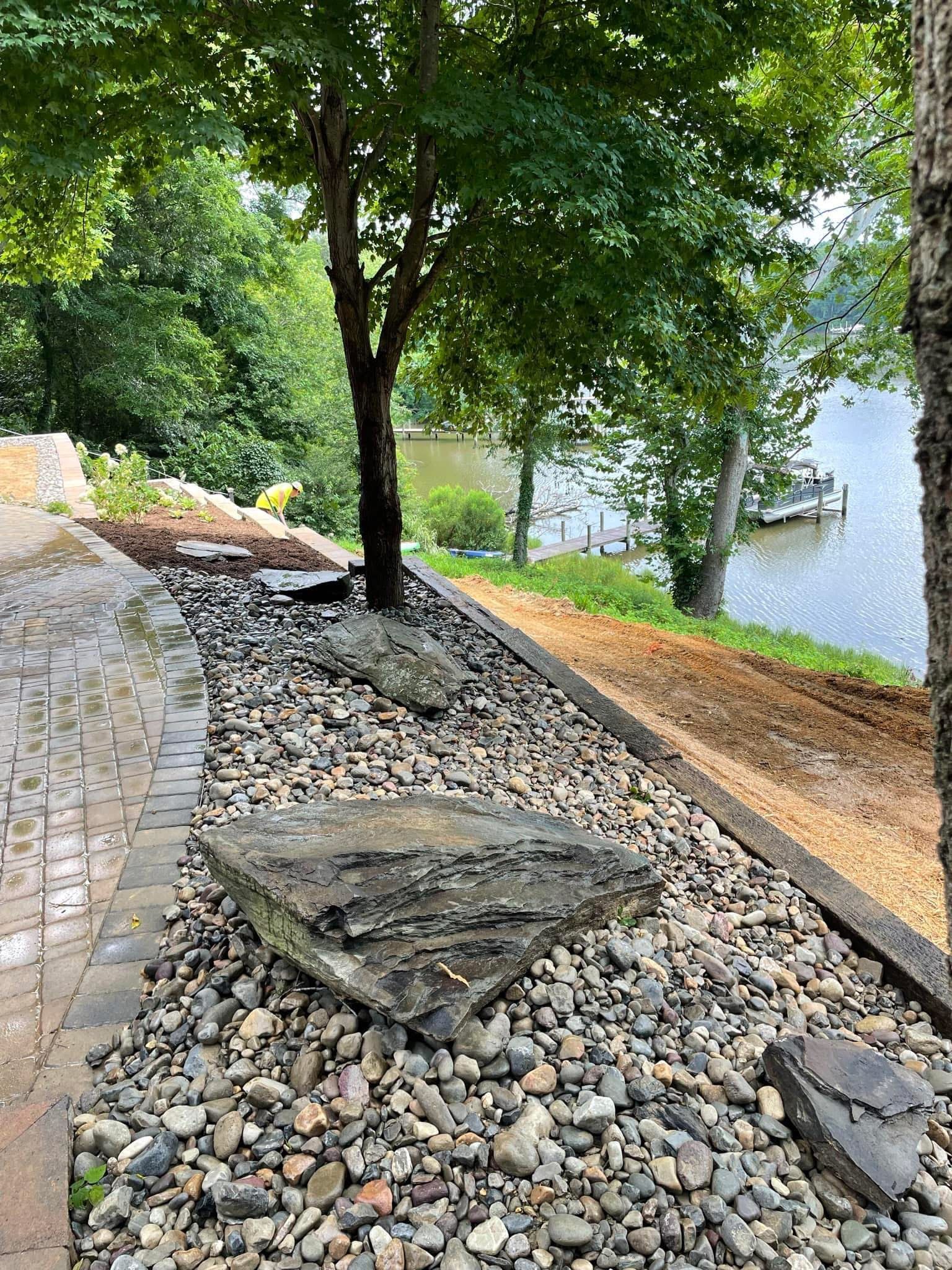 A truck is driving down a road next to a tree.