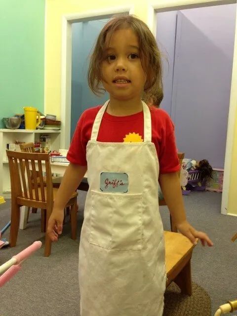 Girl Wearing Apron — York, PA — Sunshine Christian Daycare / Learning Center