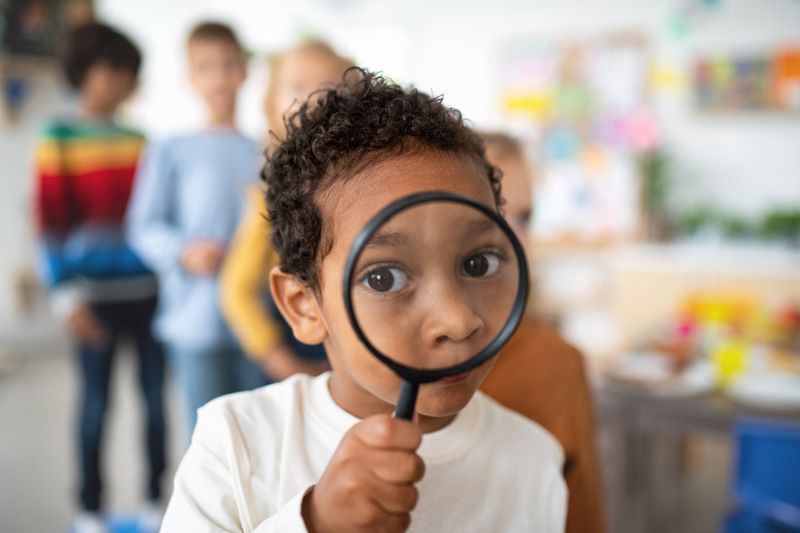 Toddler Using Magnifying Glass — York, PA — Sunshine Christian Daycare / Learning Center