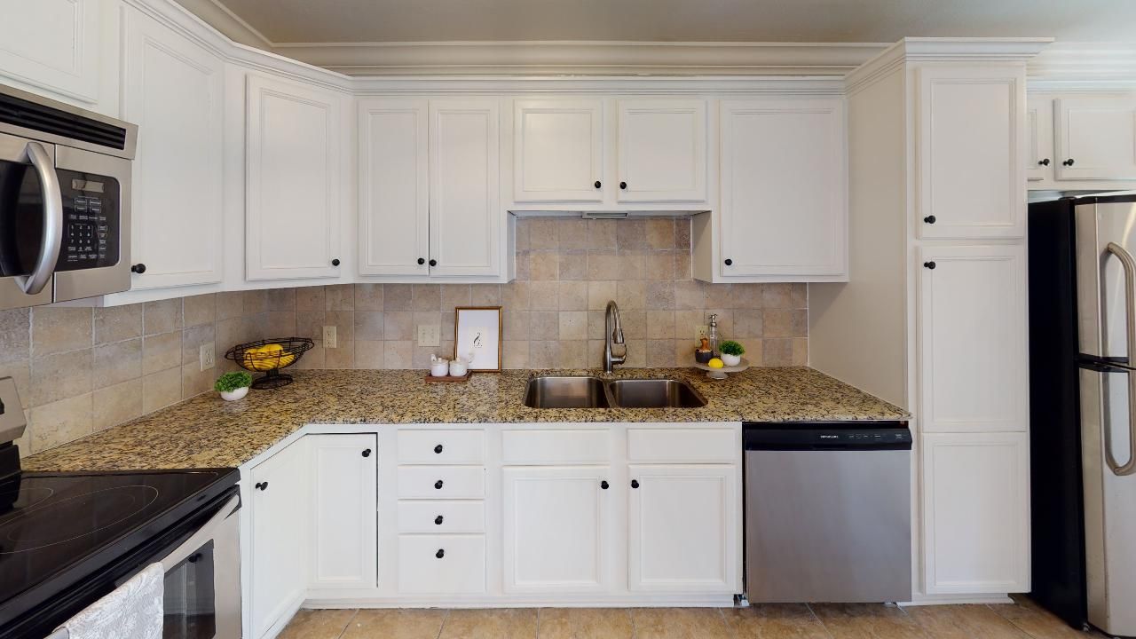 White kitchen cabinets, stainless steel appliances, granite countertops.