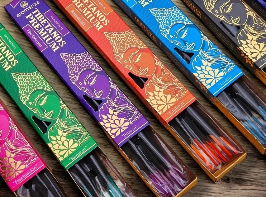 Cajas de varillas de incienso tibetanas de varios colores, dispuestas sobre una superficie de madera.