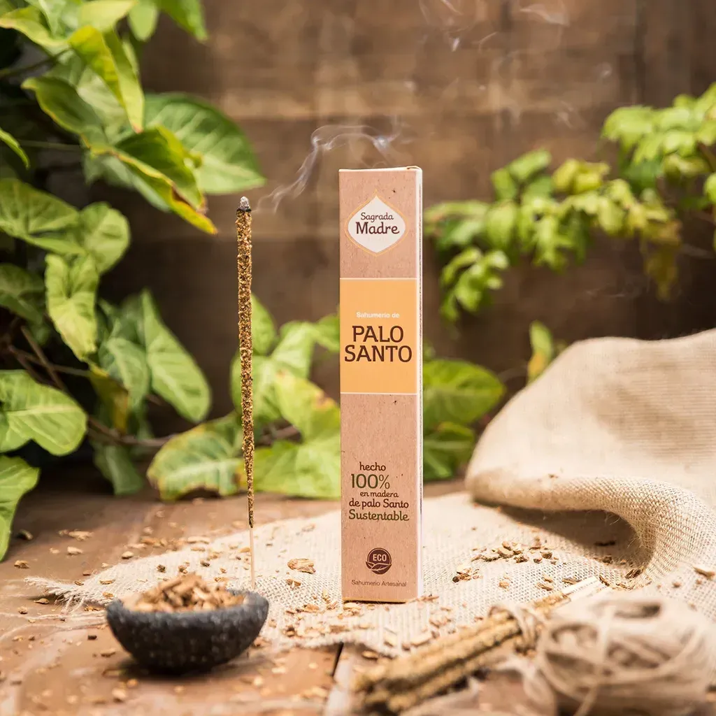 Barra de incienso de Palo Santo ardiendo, junto a un paquete