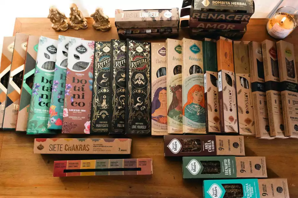 Una colección de cajas de incienso con diversos diseños, dispuestas sobre una mesa de madera.
