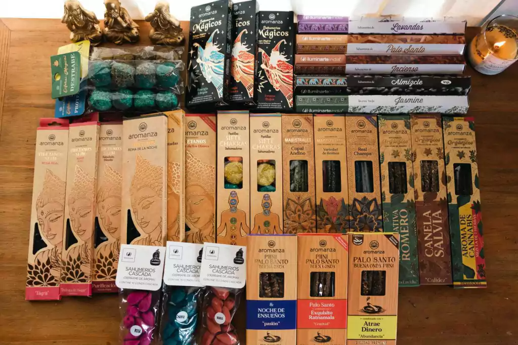 Una colección de varias cajas de incienso y algunas figuras sobre una mesa de madera.
