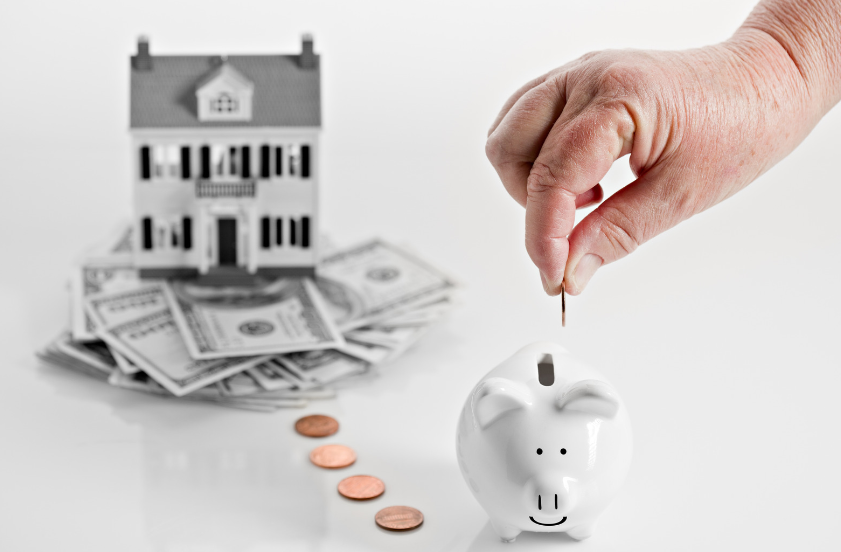 A person is putting a coin into a piggy bank.