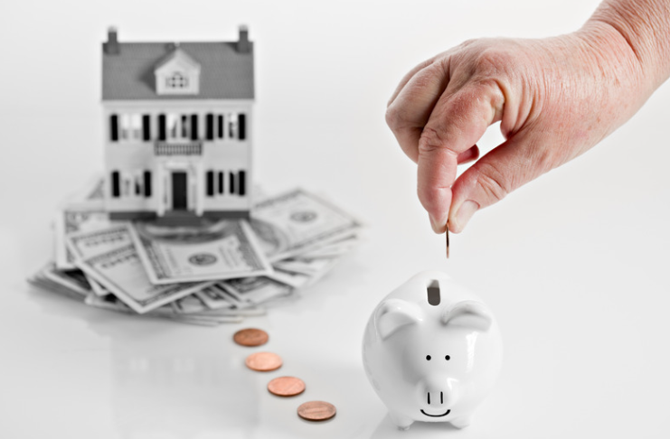 A person is putting a penny into a piggy bank.