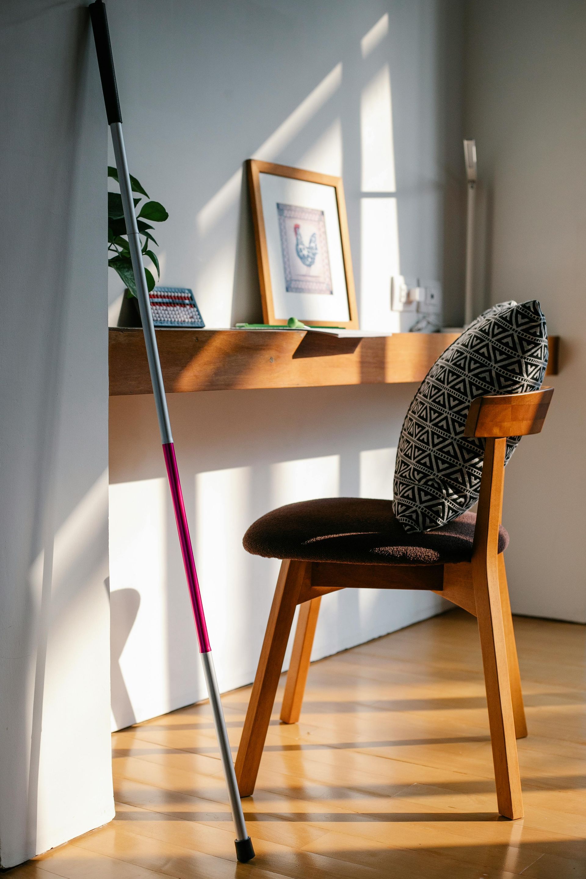 A cane is sitting next to a chair in a room.