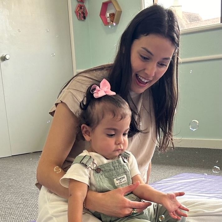 Young child playing a colorful xylophone, focused expression.
