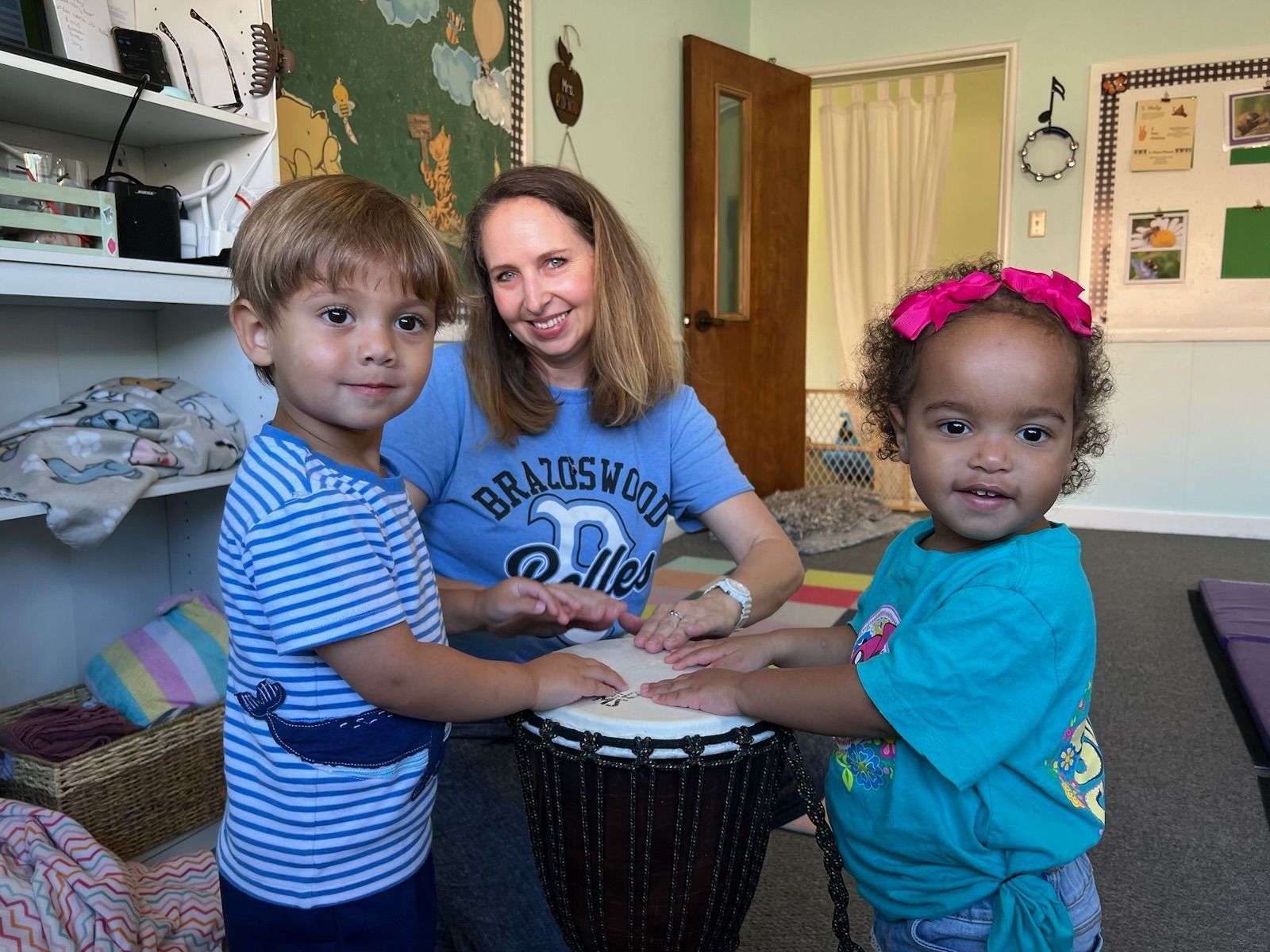 Woman and boy smiling at each other in a music room, guitars in background.