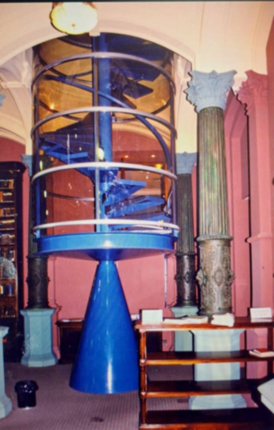 Una escalera de caracol azul en una habitación con columnas.