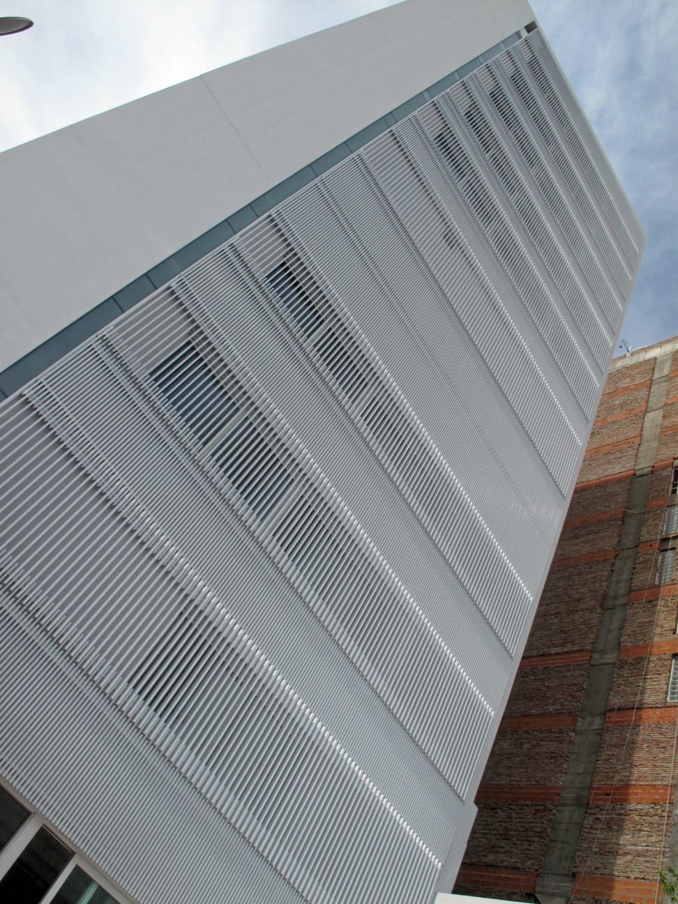 Un edificio blanco con un edificio de ladrillo al fondo.