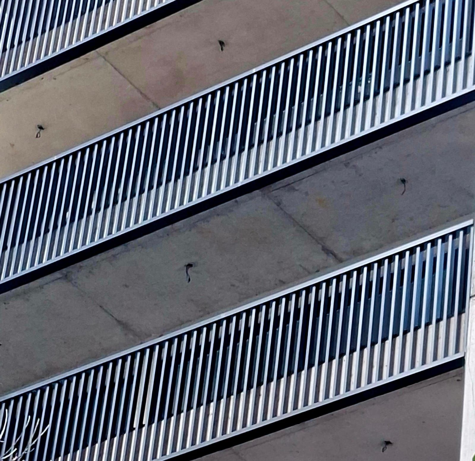 Una hilera de balcones en un edificio con barandilla de metal