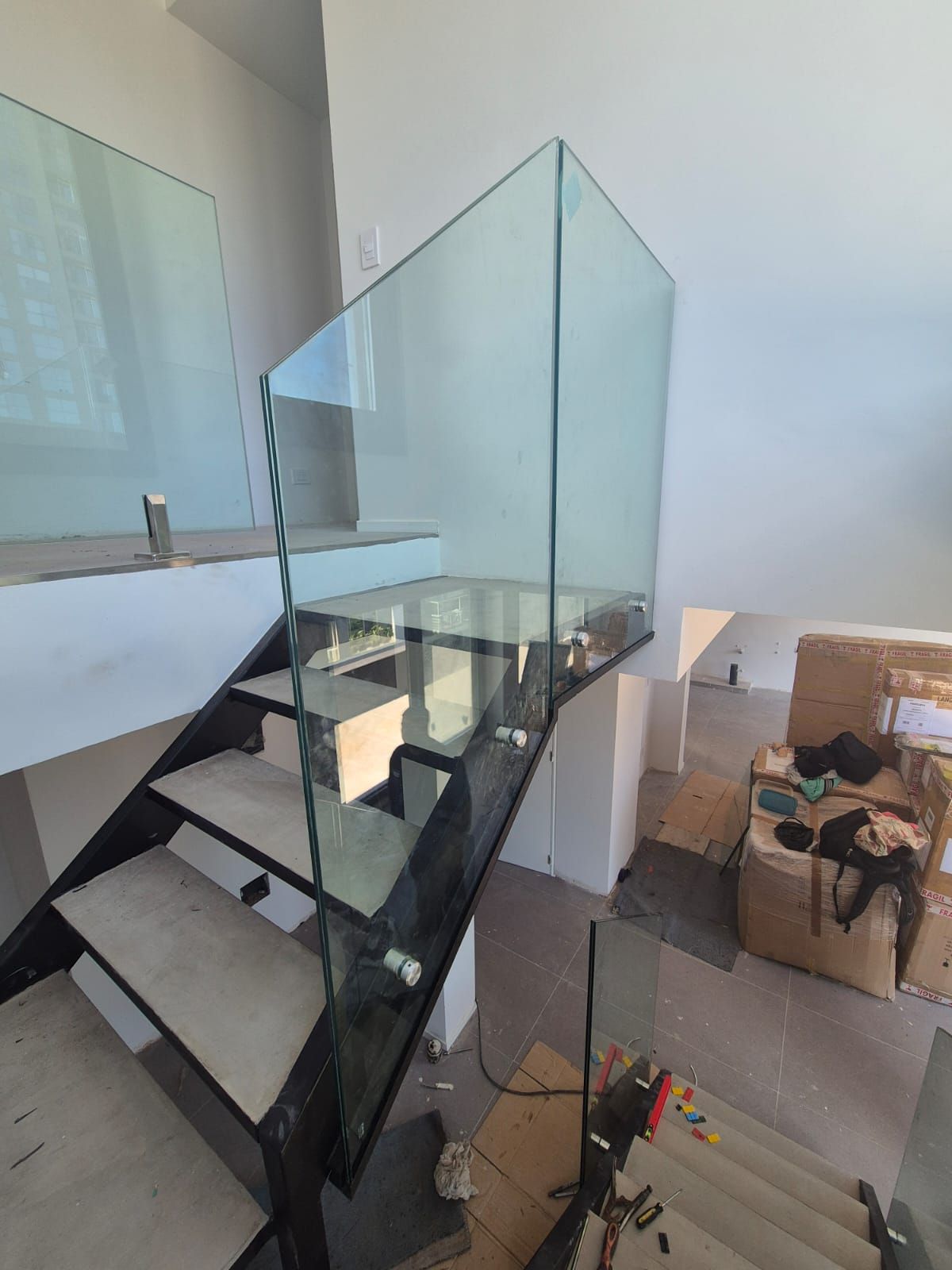 Una escalera con barandilla de cristal en una habitación.