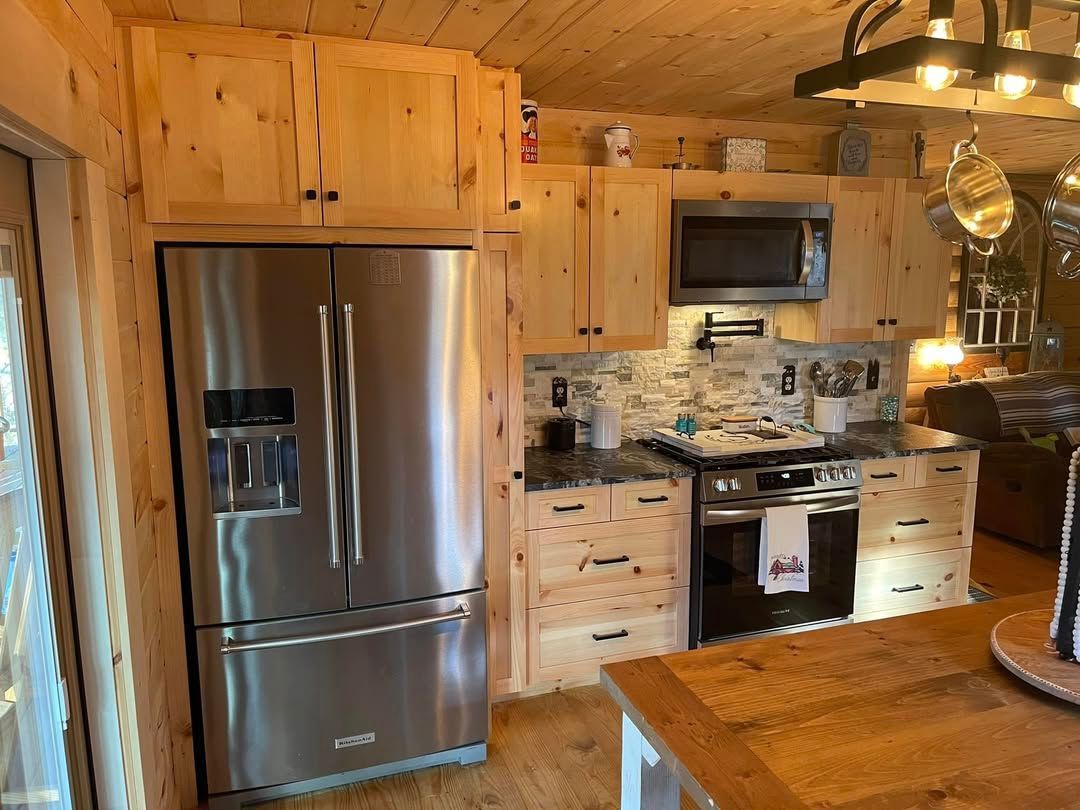 Kitchen with stainless steel refrigerator, wooden cabinets, and a stove.