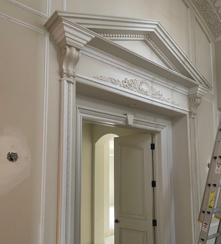Wooden cabinetry in a kitchen area with a countertop, appliances, and a small bar with seating.