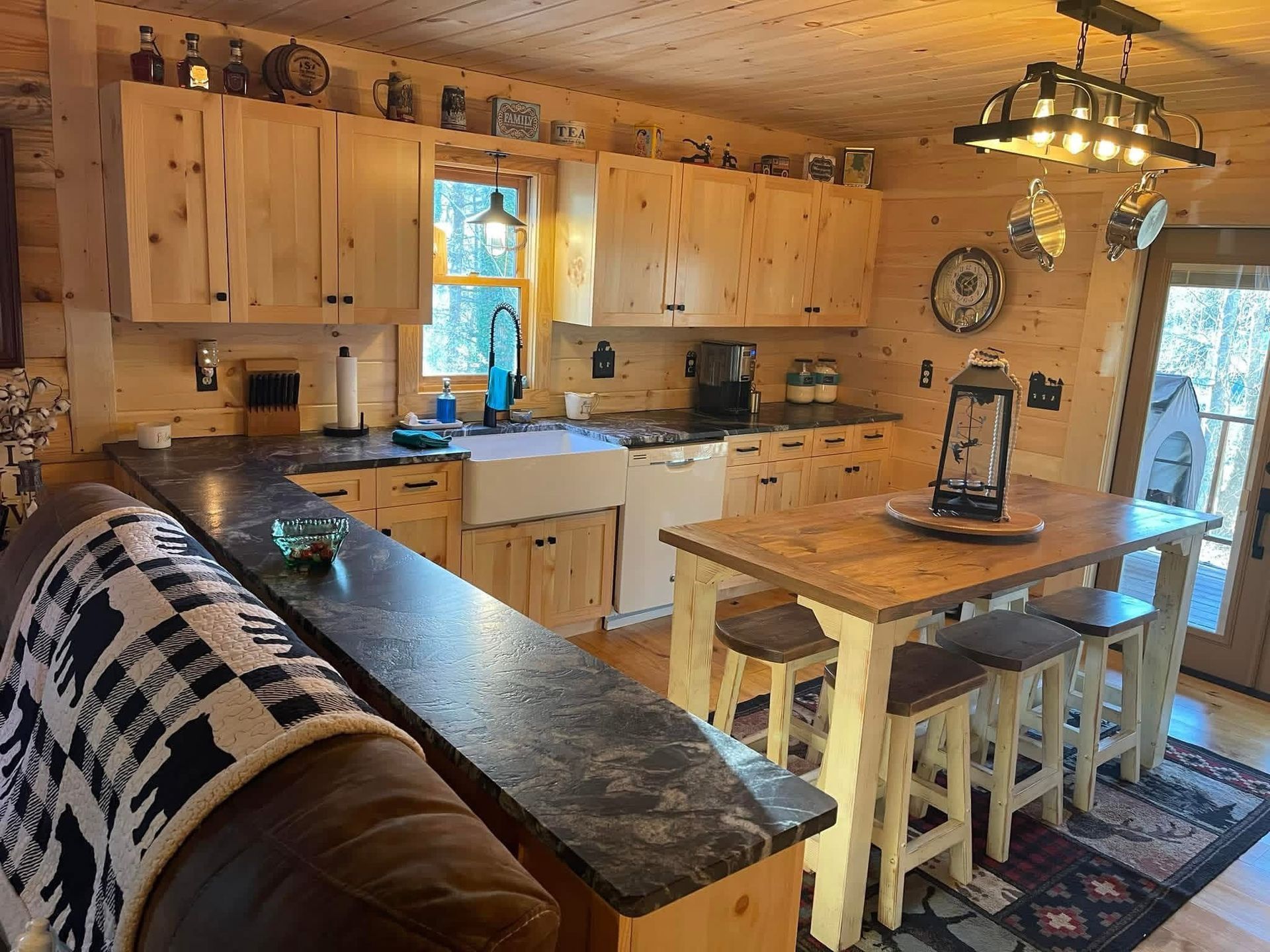 Kitchen with light wood cabinets, butcher block countertops, white farmhouse sink, and small window.