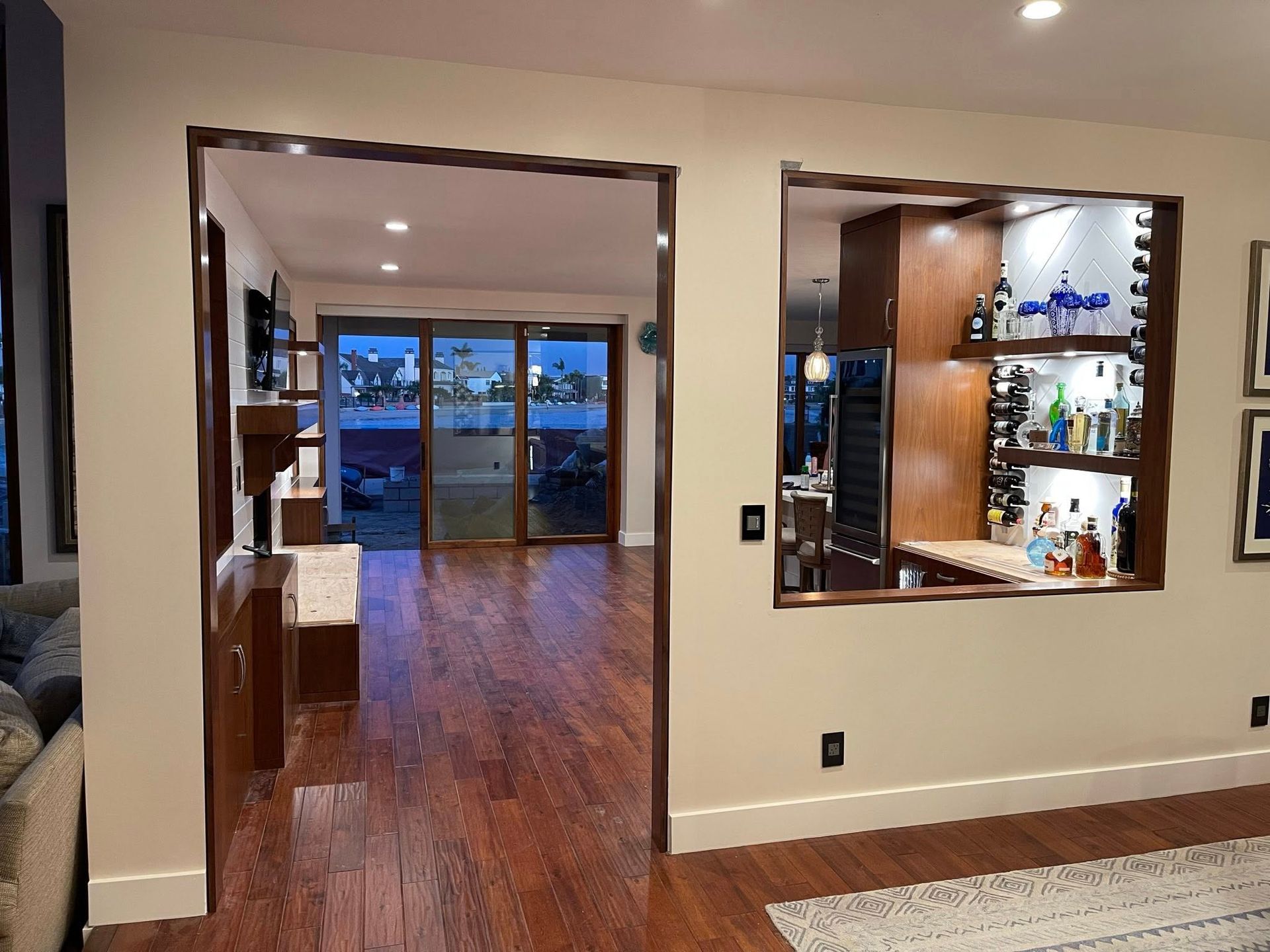 Interior view of a living space with a built-in bar and sliding glass doors leading to a waterside view.