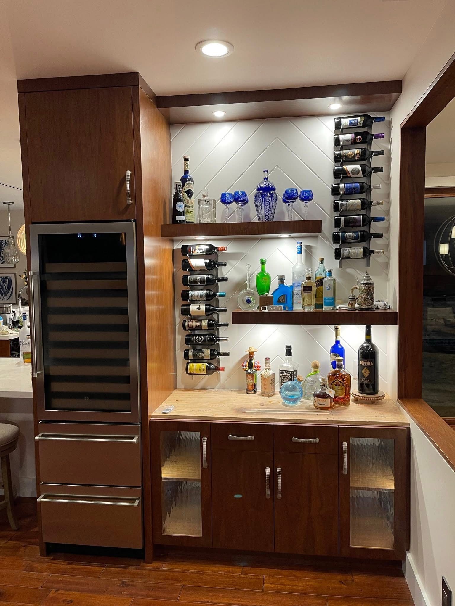 Wooden cabinetry in a kitchen area with a countertop, appliances, and a small bar with seating.