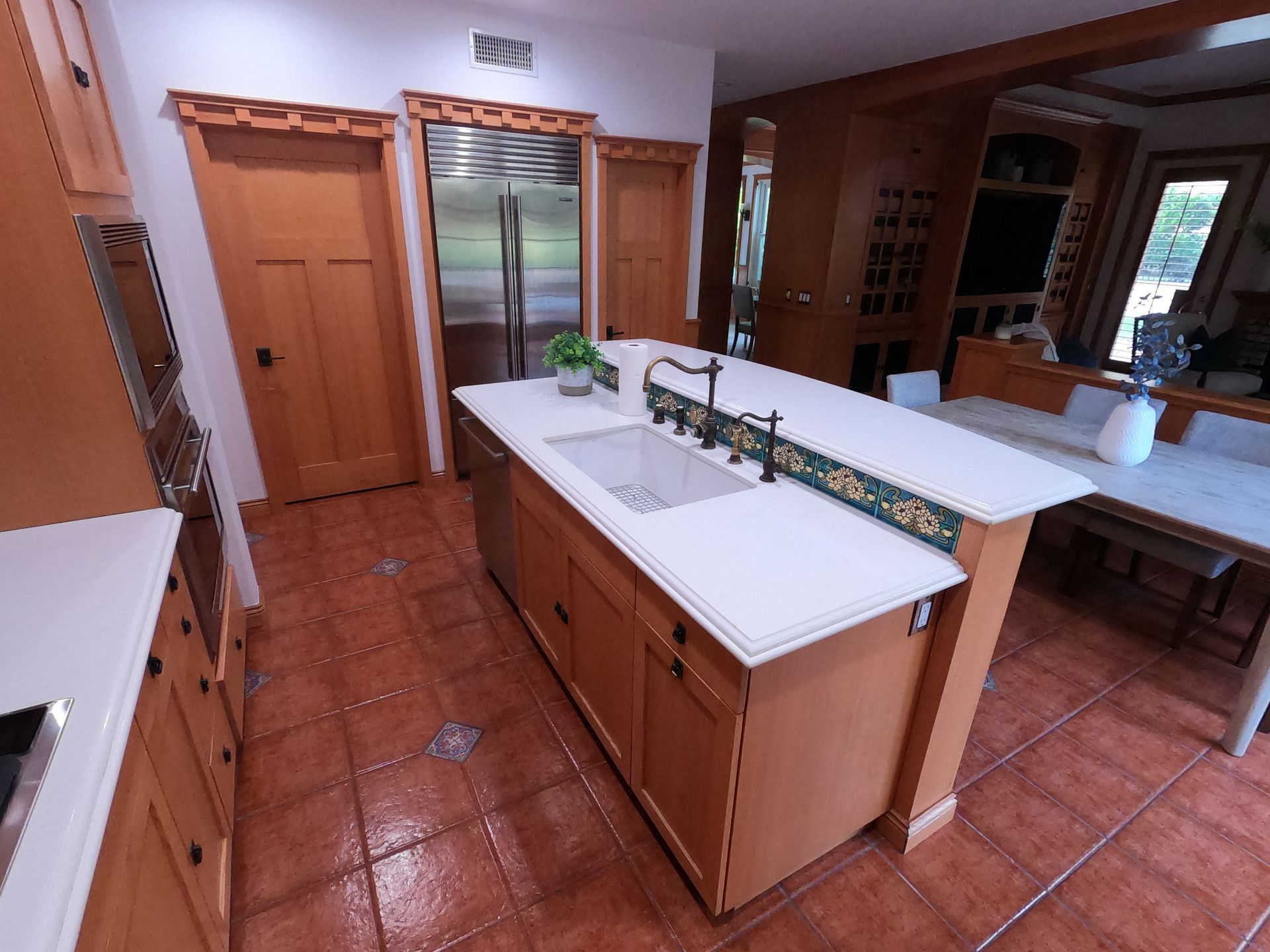 Kitchen with a central island, stainless steel refrigerator, and wooden cabinetry.