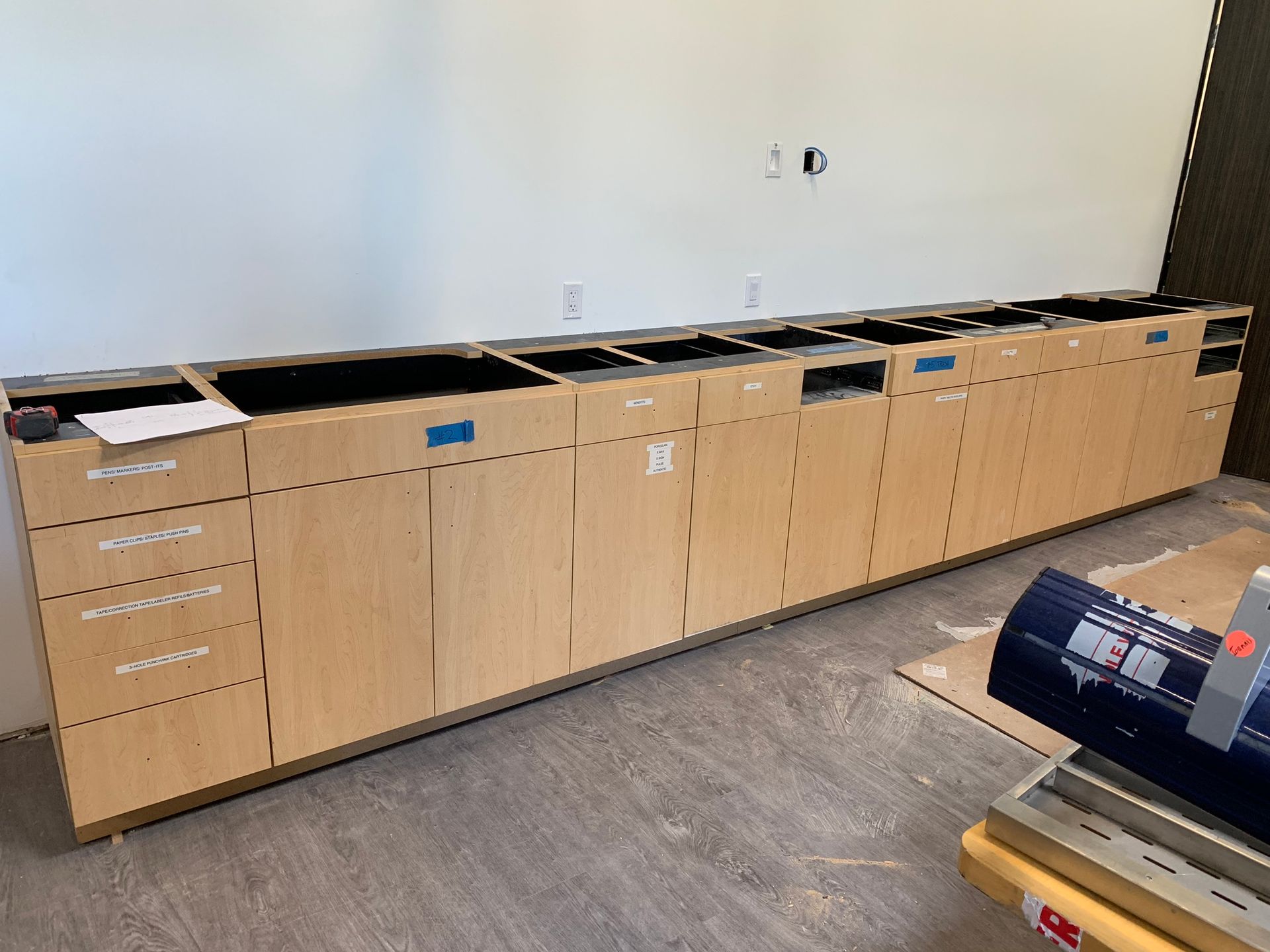 Wooden cabinets installed against a white wall. The cabinets have openings for appliances.