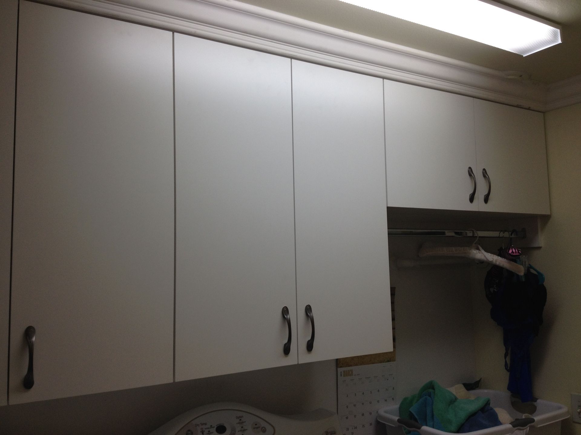 White cabinets above a washing machine in a laundry room.