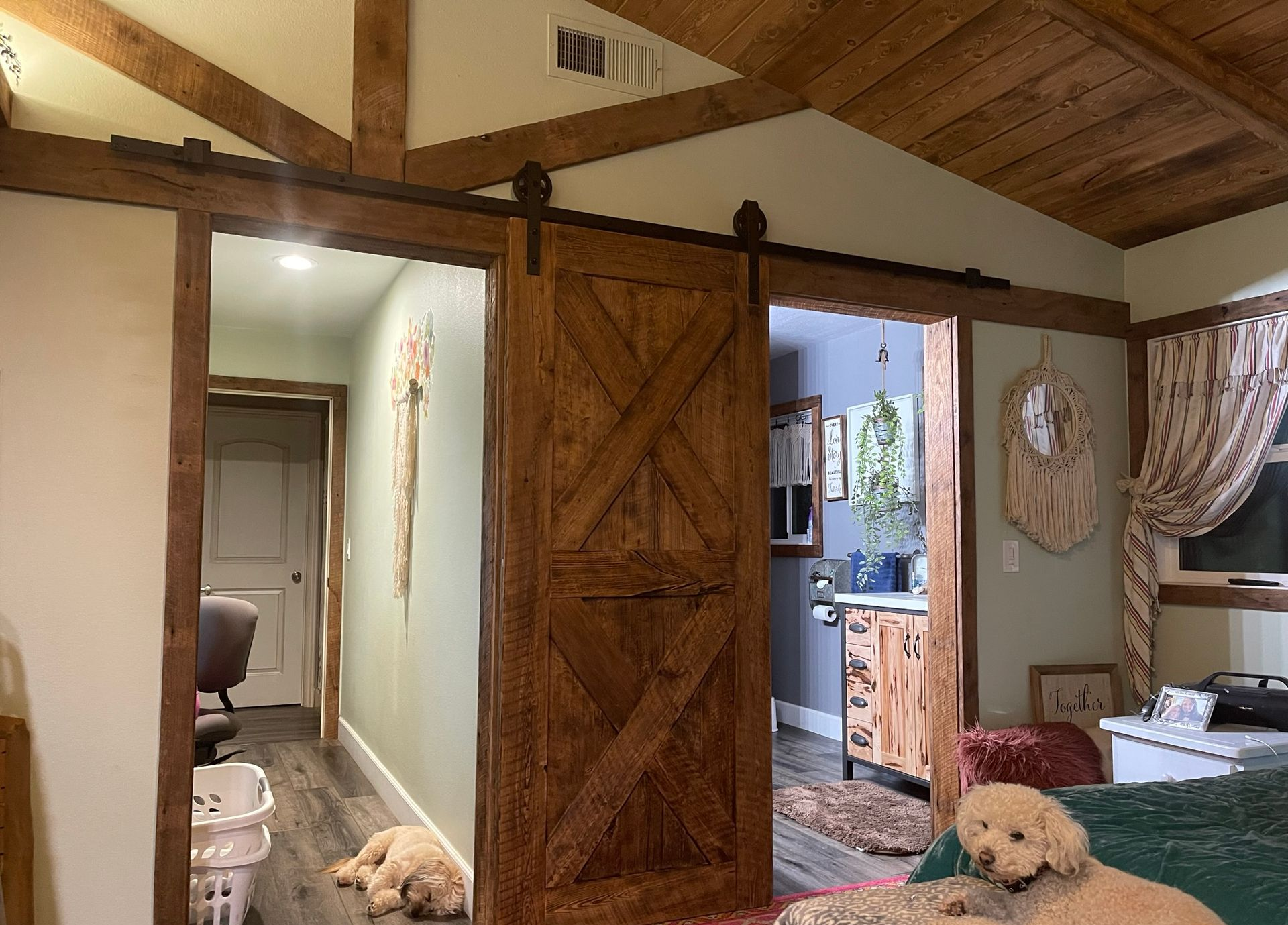 Brown wooden door in a workshop setting with a person in the background, door has a dark handle and is next to wood panels.